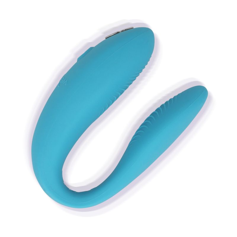Türkisfarbener We-Vibe Sync Go. U-förmiges Design mit geriffelten Oberflächen. Auf weißem Hintergrund.