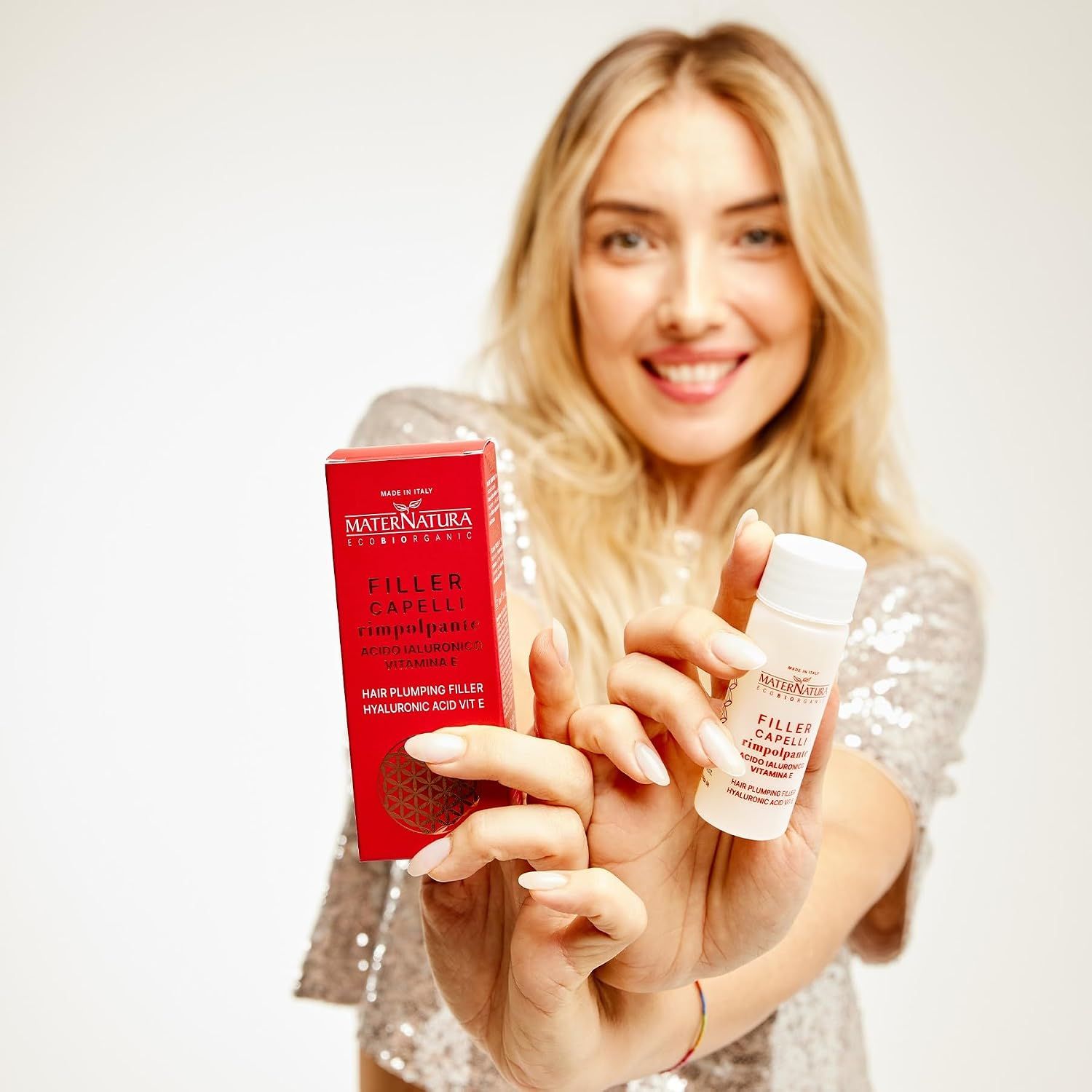Frau hält Maternatura Hair Filler Fläschchen und Box. Hyaluronsäure und Vitamin E.