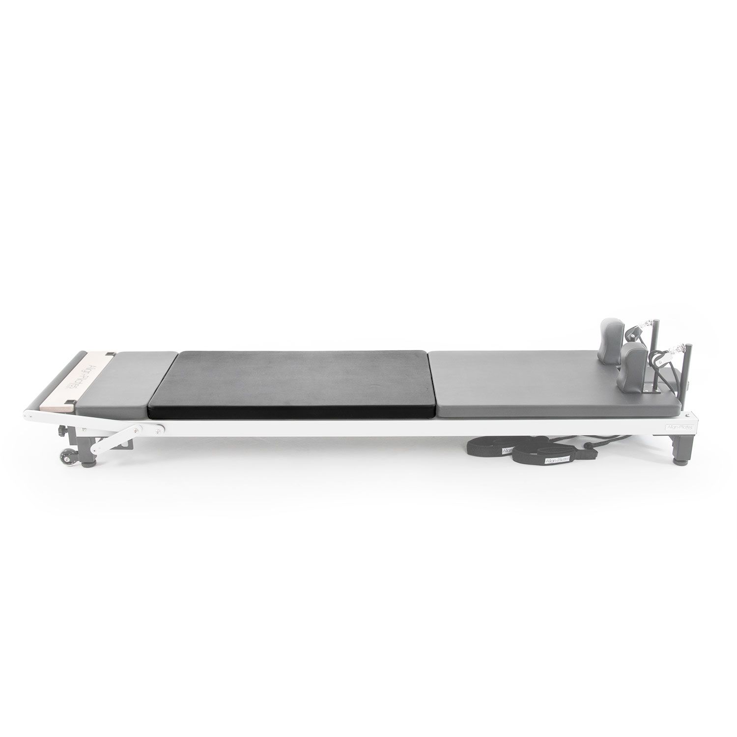 Pilates C2 Mat Converter. Graue Liegefläche mit schwarzem Polster. Metallrahmen mit Rollen und Zubehör.