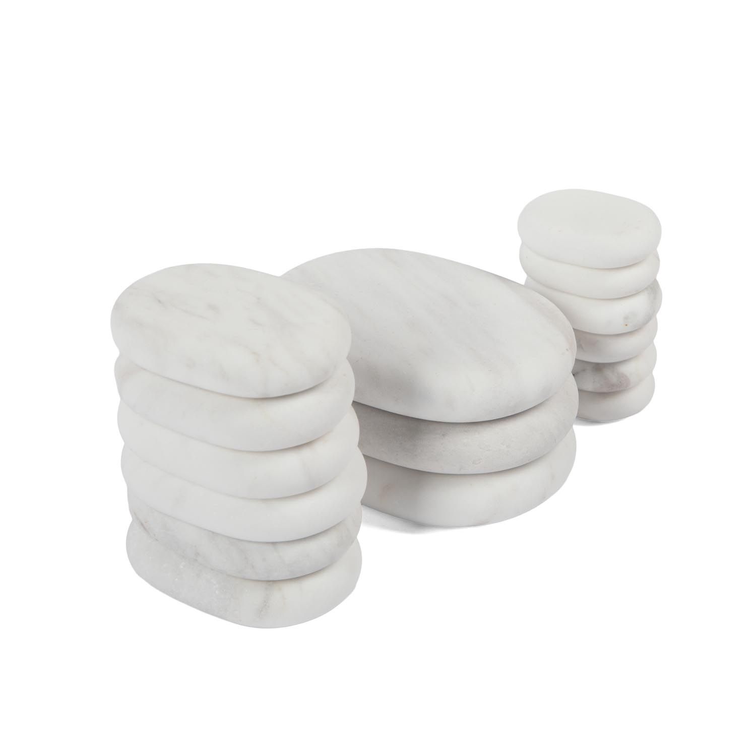 Mehrere weiße, ovale Steine in Stapeln angeordnet. Auf weißem Hintergrund.