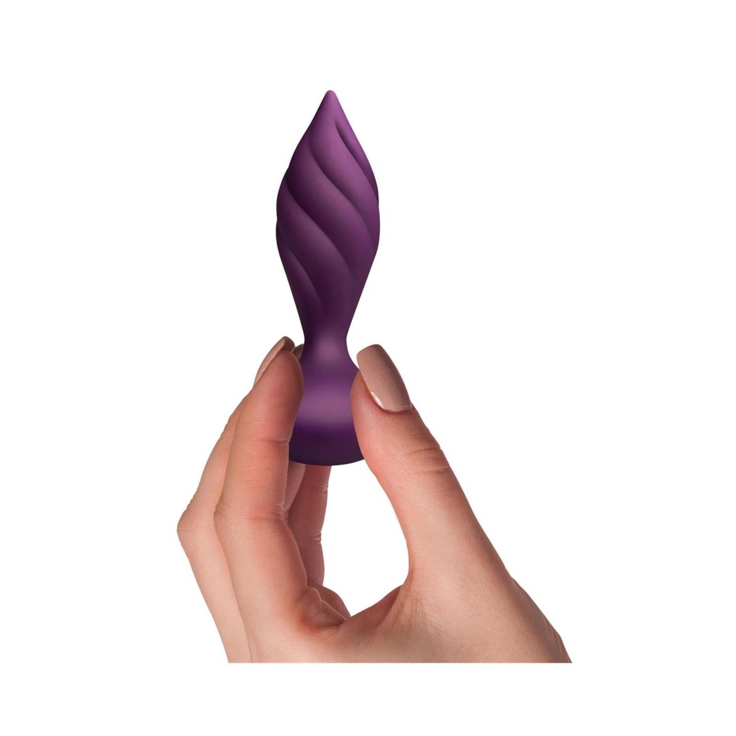 Hand hält einen lila Vibrator mit spiralförmiger Textur. Der Vibrator hat eine tropfenförmige Basis.