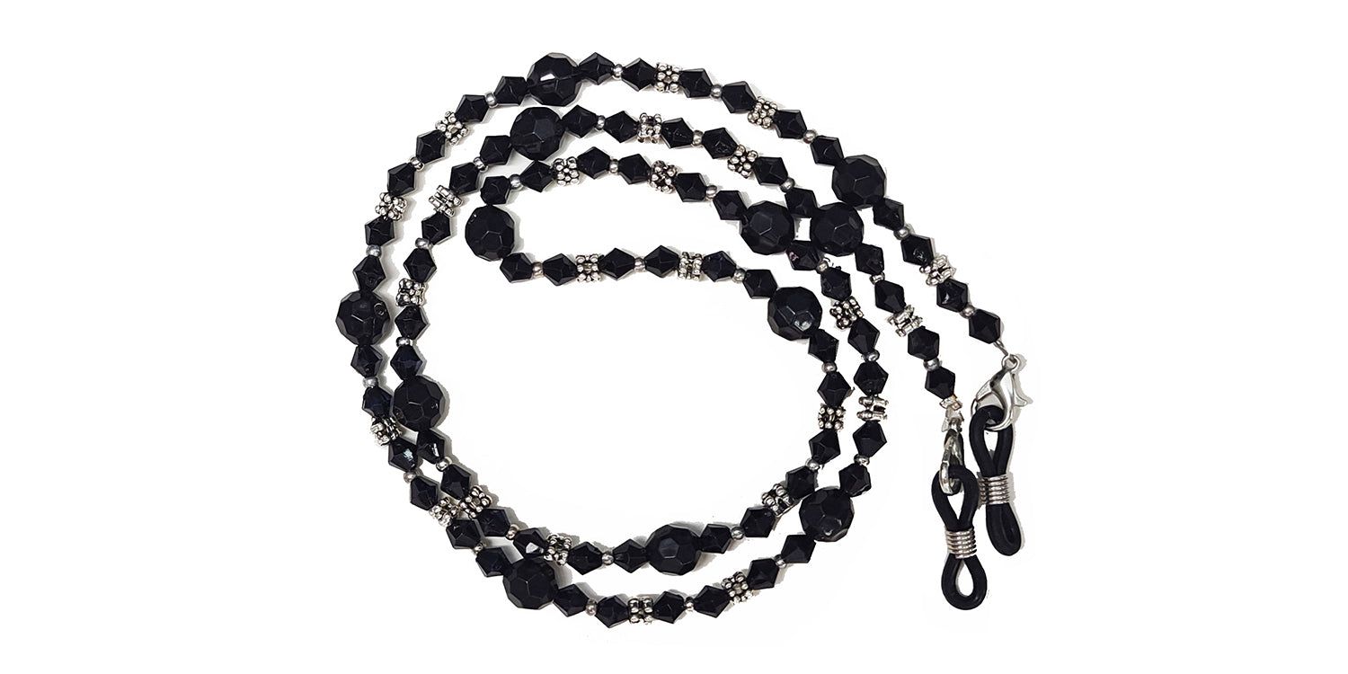 Brillenkette mit schwarzen Perlen und Kristallen. Metallene Verbindungsstücke. Schlaufen zur Befestigung an der Brille.