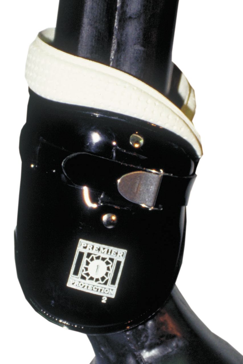 Schwarze AMKA Streichkappen Universal an einem Pferdebein. Mit Schnalle und Riemen befestigt. Logo 'Premier Protection'.