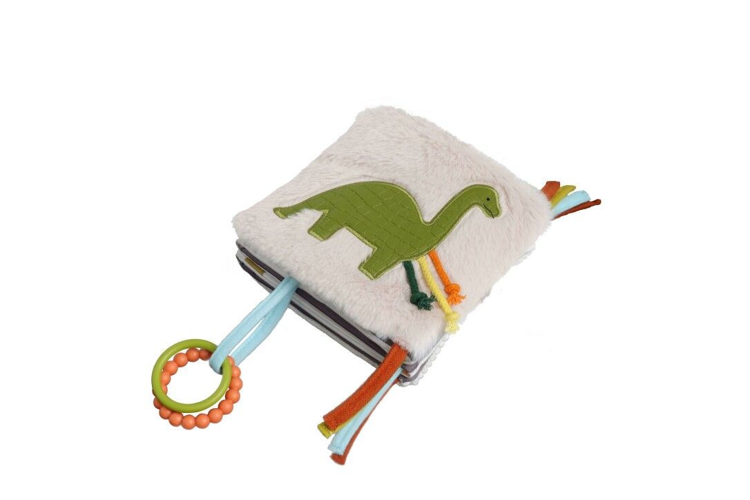 Quadratisches Stoffbuch mit grünem Dino-Motiv. Bunte Bänder und Ringe zum Greifen. Flauschiges Material.