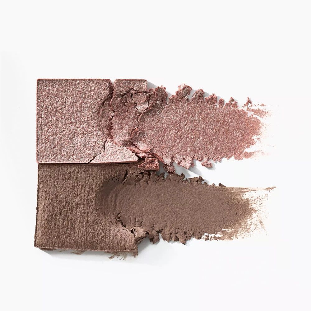 Zwei Lidschattenfarben, eine braun, eine schimmernd, auf weißem Hintergrund. Die Textur ist als Abstrich dargestellt.