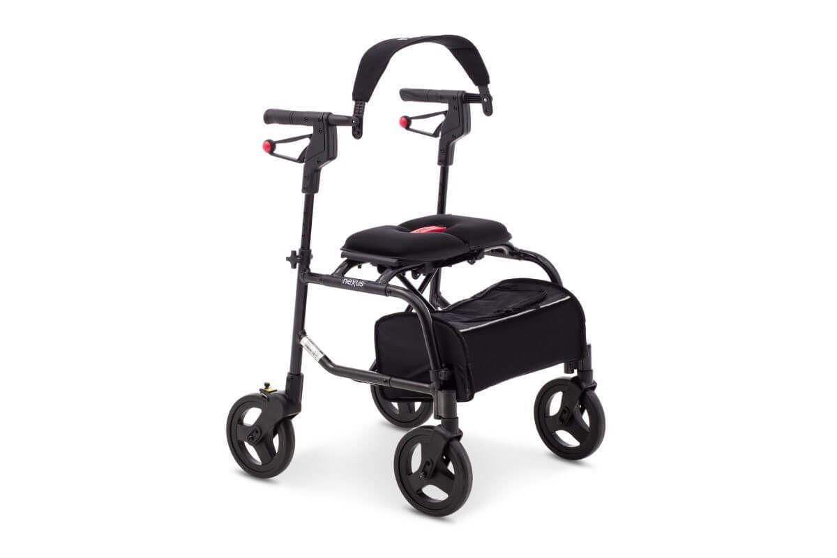 Anthrazitfarbener Rollator mit Sitz, Rückenlehne und Einkaufstasche. Vier Räder, schwarze Griffe.