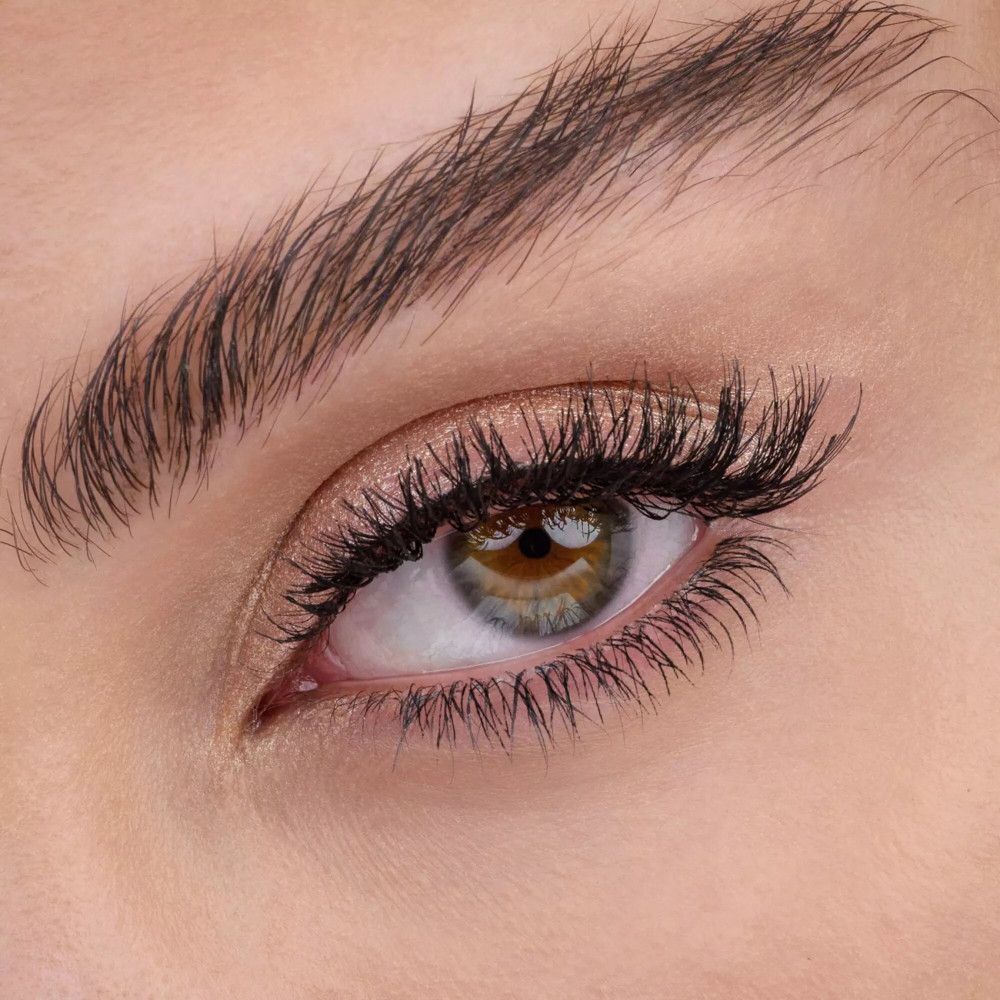 Nahaufnahme eines Auges mit Wimperntusche und goldfarbenem Lidschatten.