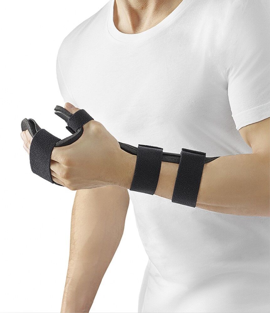 Handorthese, schwarz, mit Klettverschlüssen. Am Handgelenk und Daumen fixiert. Träger mit weißem T-Shirt.