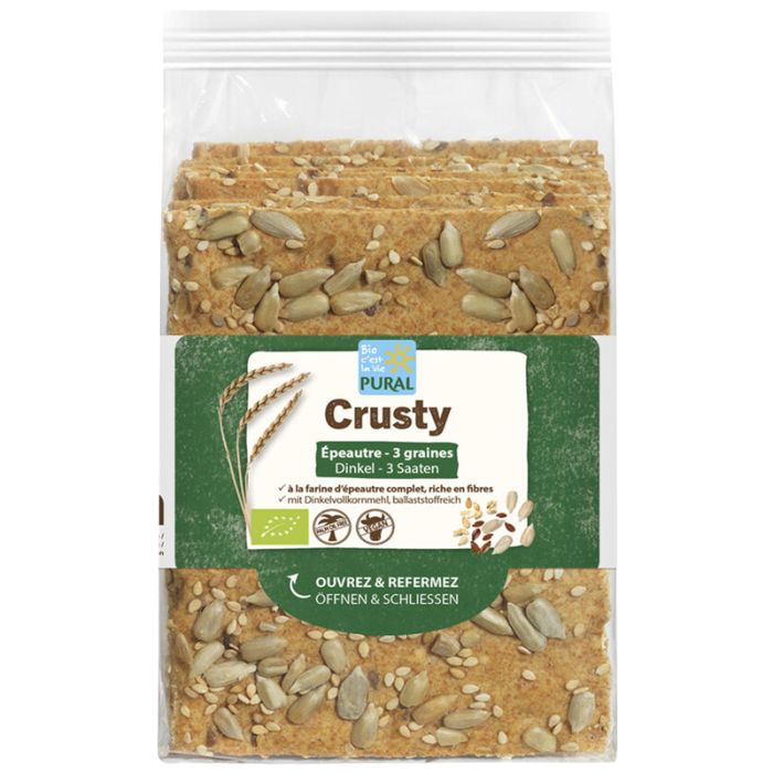 Verpackung mit Pural Crusty Dinkel-Cräckern. Aufschrift "Crusty", "Dinkel-3 Saaten". Sichtbar Sonnenblumenkerne und Sesam. Bio-Siegel.