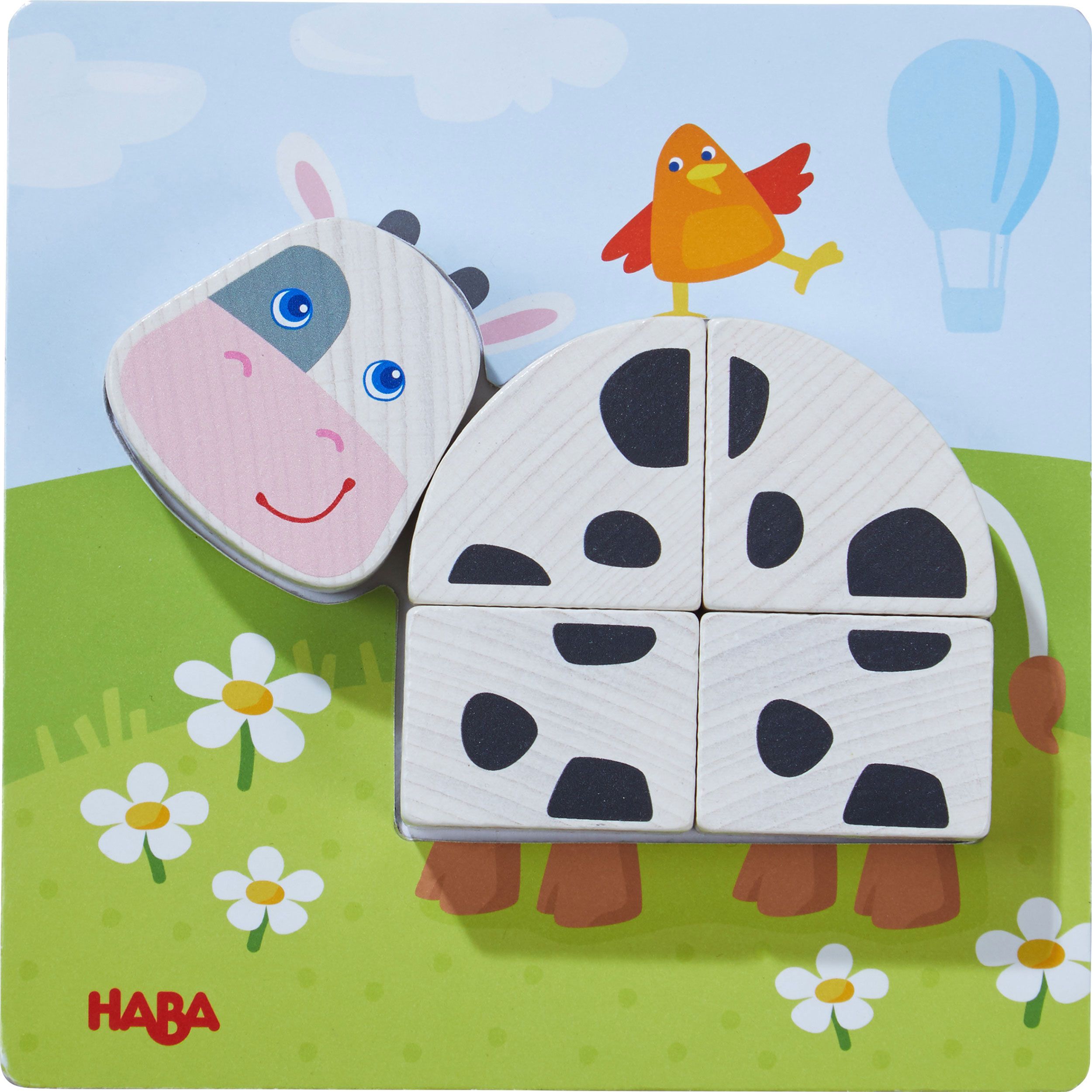 Puzzle mit Kuh-Motiv. Kuh mit schwarzen Flecken, gelbem Huhn. HABA-Logo. Holzspielzeug.