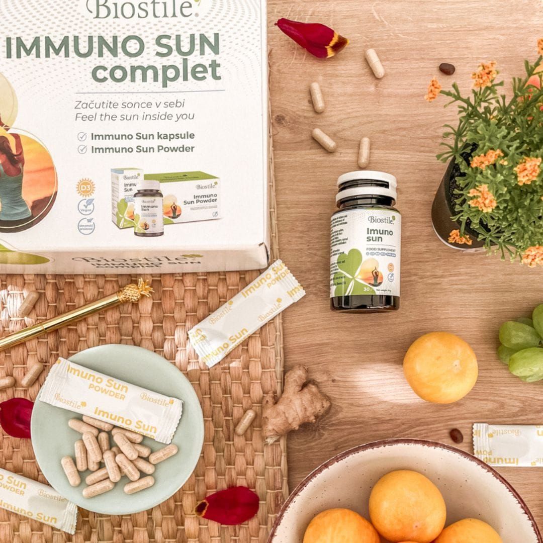 Biostile Immuno Sun Komplett Karton mit Kapseln und Päckchen auf Holztisch.