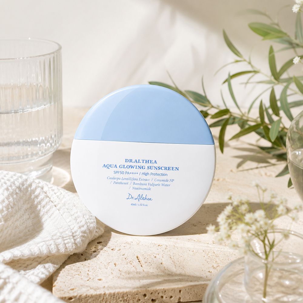 Dr. Althea Aqua Glowing Sonnencreme in weiß-blauem Behälter, mit Text.