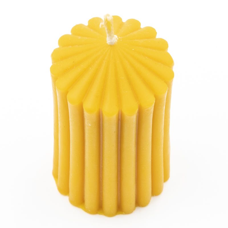 Gelbe Wachskerze mit geriffelter Oberfläche. Zylindrische Form mit spitz zulaufendem oberen Ende. Docht sichtbar.