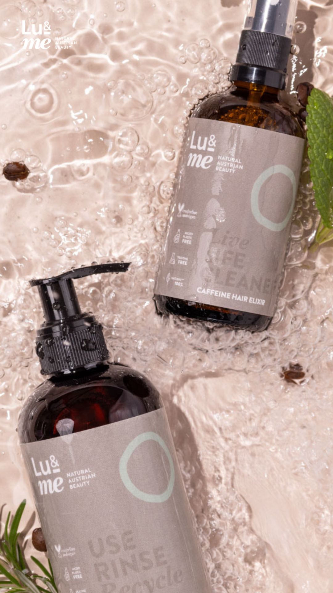 Zwei braune Flaschen im Wasser. Aufschrift: Lu&me, Live Life Cleaner, Caffeine Hair Elixir. Kaffeebohnen und Minze.