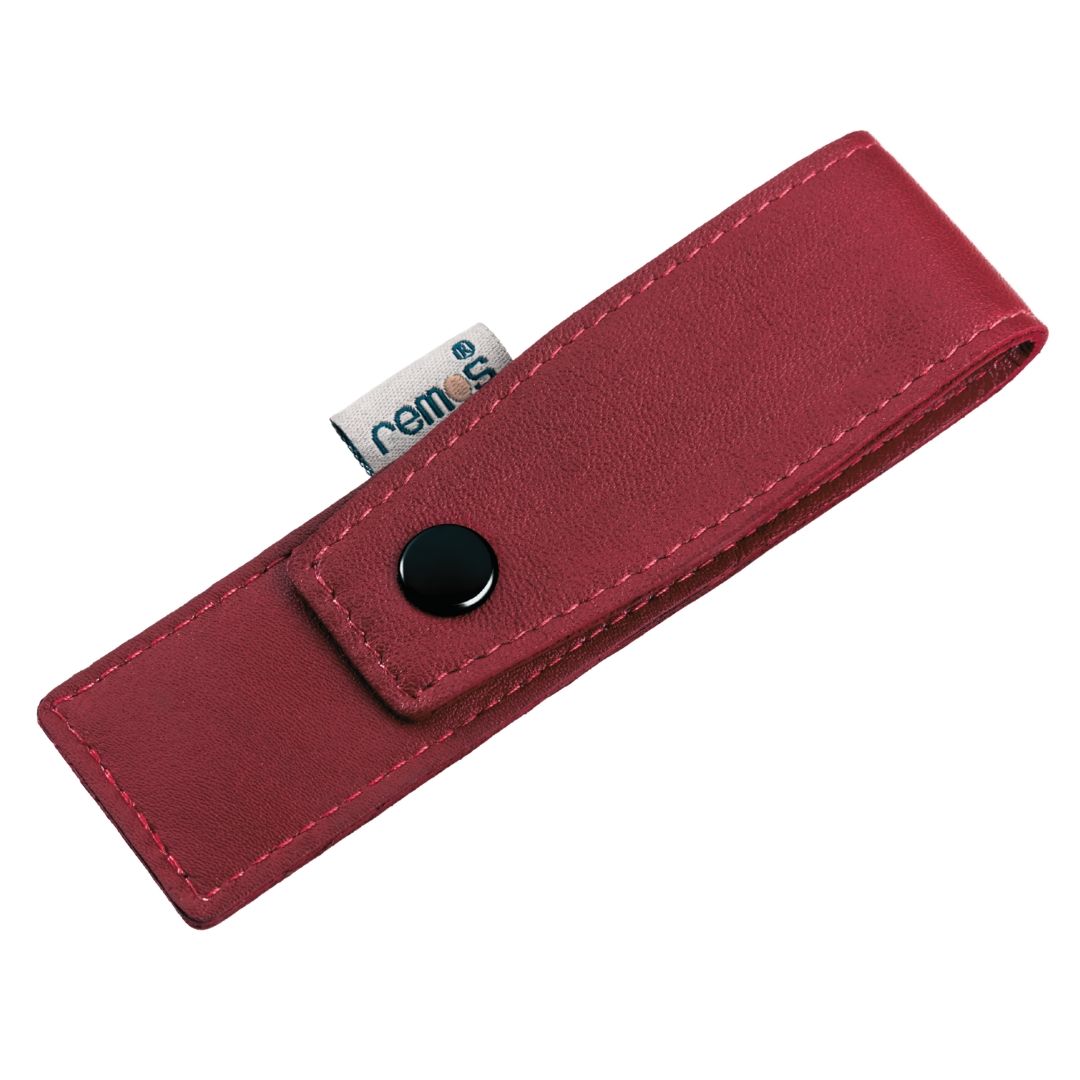 Etui aus rotem Leder mit schwarzem Knopf und Label. Label mit "remos" Schriftzug.