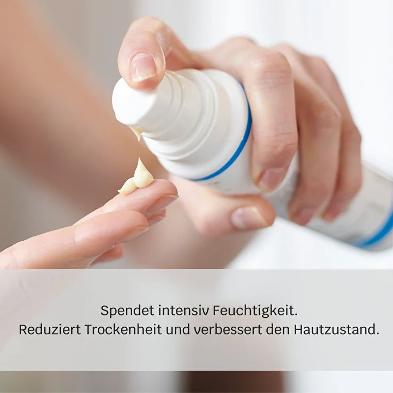 Weiße Flasche mit Spender. Creme wird auf Finger aufgetragen. Text: Spendet intensiv Feuchtigkeit. Reduziert Trockenheit und verbessert den Hautzustand.