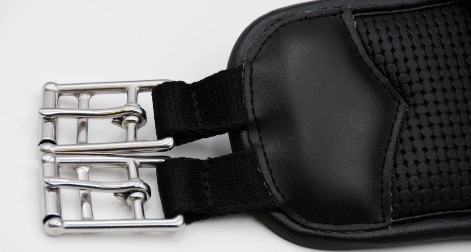 Nahaufnahme eines Sattelgurts mit Metallverschlüssen. Schwarzes Neopren, gepolstert. Metallösen und schwarze Riemen.
