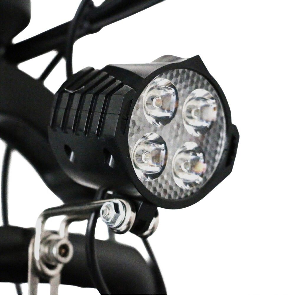 Nahaufnahme eines Scheinwerfers mit vier LED-Leuchten. Der Scheinwerfer ist schwarz und hat ein strukturiertes Gehäuse.