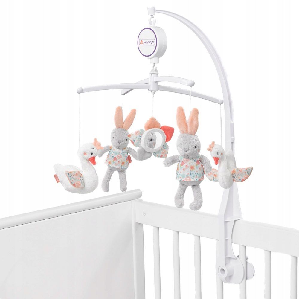 Mobile am Kinderbett befestigt. Stofftiere: zwei Hasen, zwei Schwäne und ein Spiegel. Weißes Gestell. Rosa und blaue Akzente.