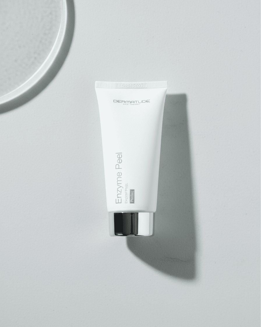 Ein weißer Schlauch 'Enzyme Peel' auf einem hellgrauen Untergrund.