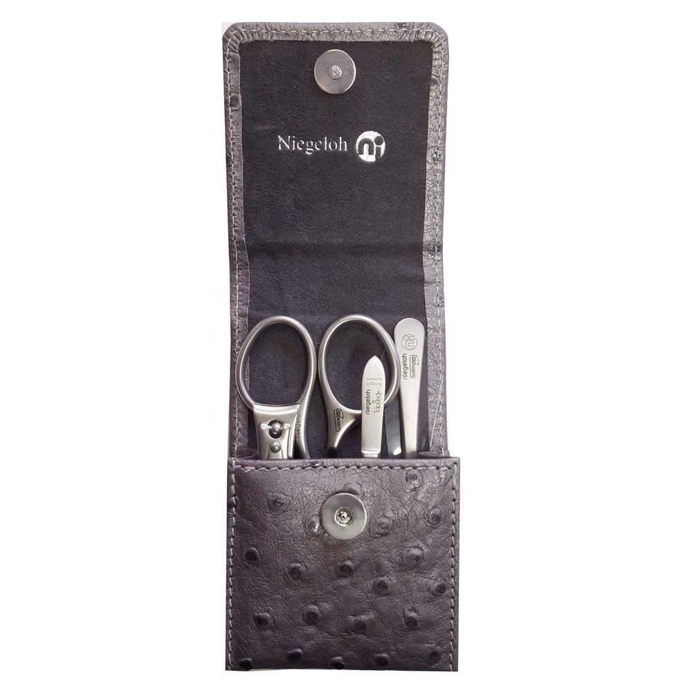 Graues Maniküre-Set in Etui mit Straußenleder-Optik. Enthält Schere, Nagelfeile und Pinzette. Marke Niegeloh.