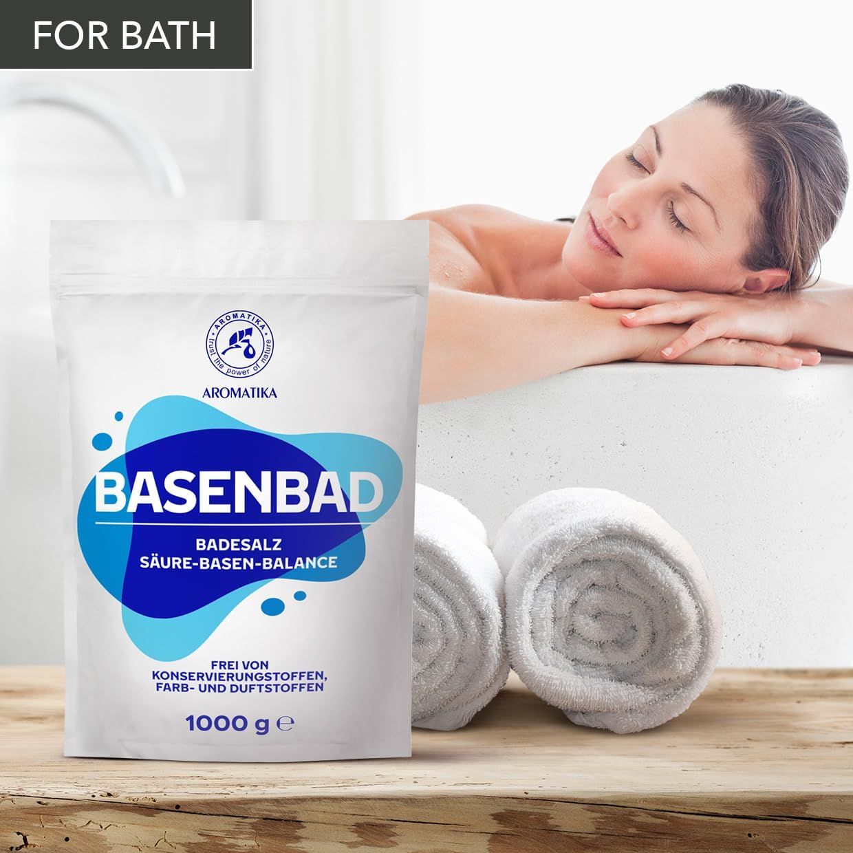 Weiße Verpackung mit blauem Design. BASENBAD, Badesalz, Säure-Basen-Balance. Logo: AROMATIKA. Frau liegt in Badewanne. Handtücher. Text: Frei von Konservierungsstoffen, Farb- und Duftstoffen. 1000 g.