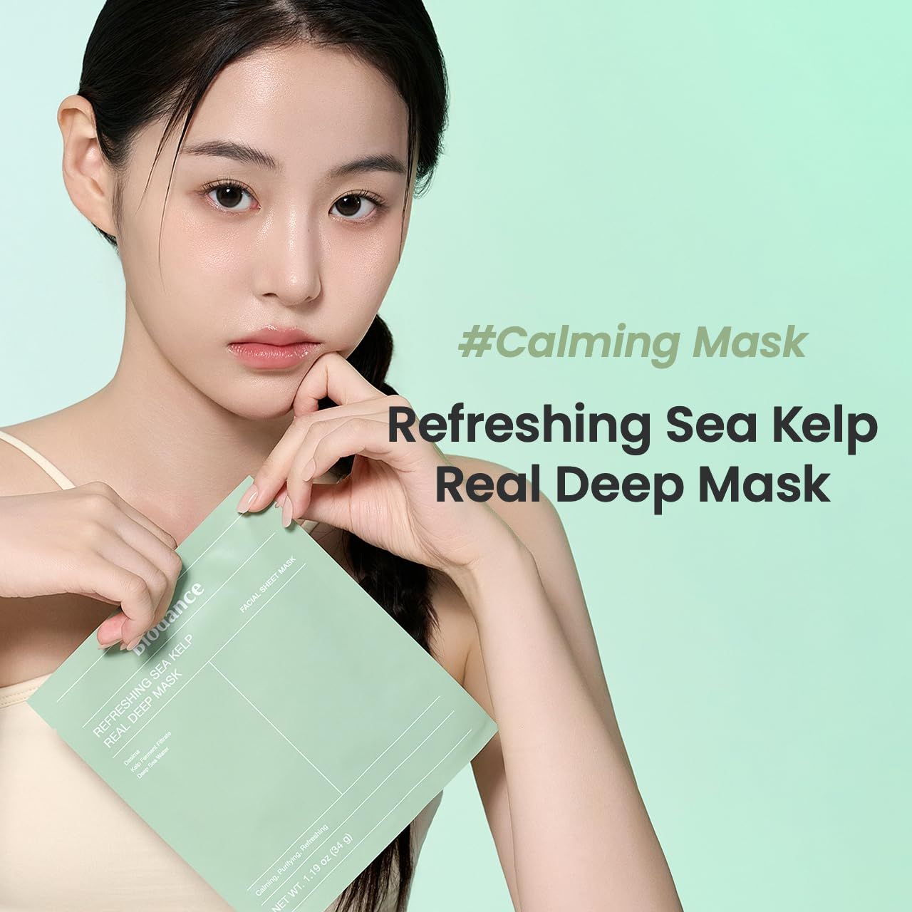 Eine Frau hält eine Biodance Refreshing Sea Kelp Real Deep Mask. Text: #Calming Mask. Grünliche Verpackung.