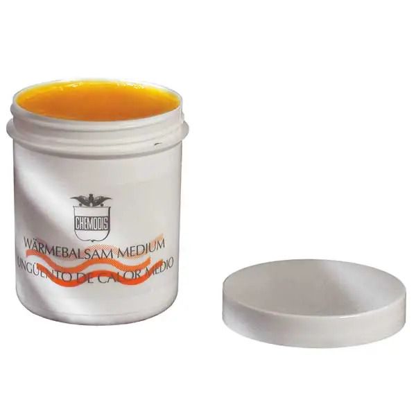 Weißer Tiegel mit orangefarbenem Inhalt und offenem Deckel. Aufschrift: WARMEBALSAM MEDIUM. Marke: CHEMODIS.