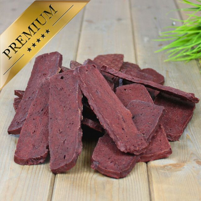 Haufen von Rindfleischstreifen auf Holzuntergrund. Goldfarbenes Premium-Etikett.