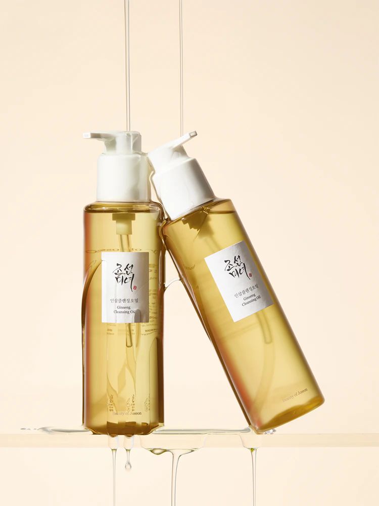 Zwei Flaschen Beauty of Joseon Revive Serum, eine steht, die andere liegt, mit Tropfen von Serum.