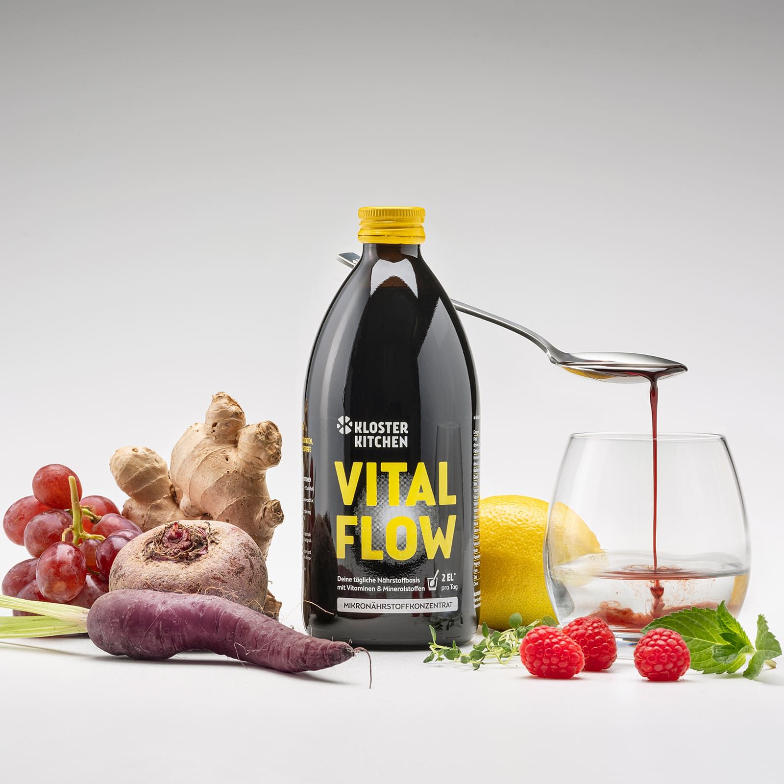 Flasche VITAL FLOW, daneben Zutaten: Trauben, Ingwer, Rote Bete, Karotte, Zitrone, Himbeeren, Glas mit Flüssigkeit.