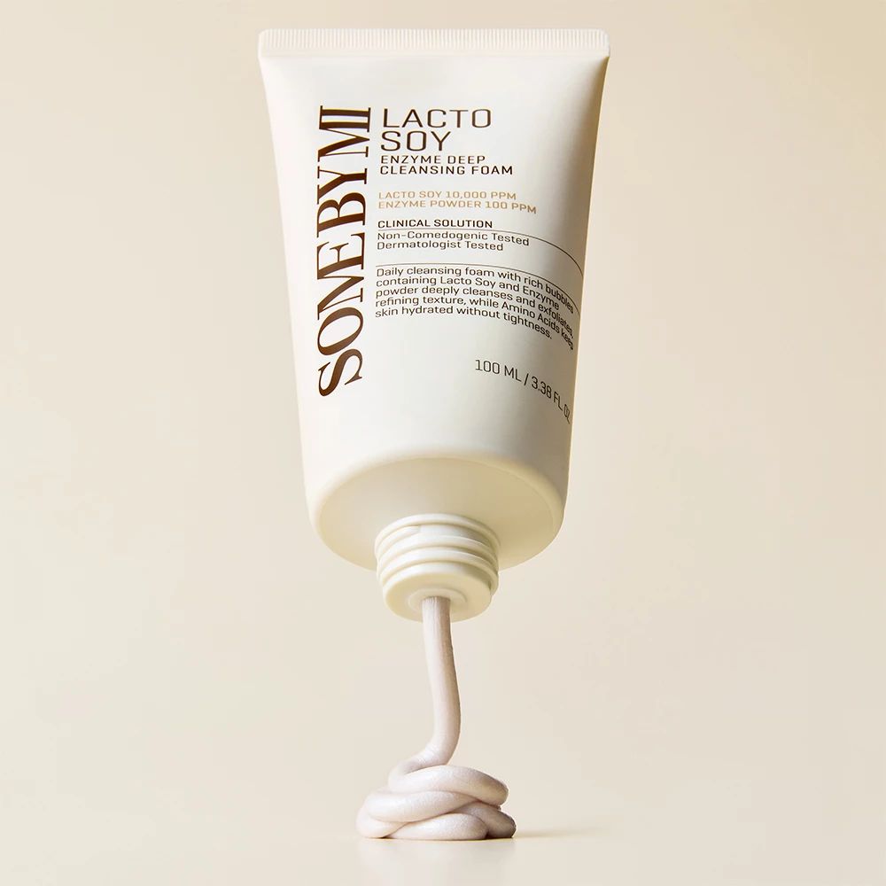 Eine Tube mit weißem Reinigungsschaum, aus der ein Strang des Produkts herausquillt. Auf der Tube steht "Lacto Soy Enzyme Deep Cleansing Foam".