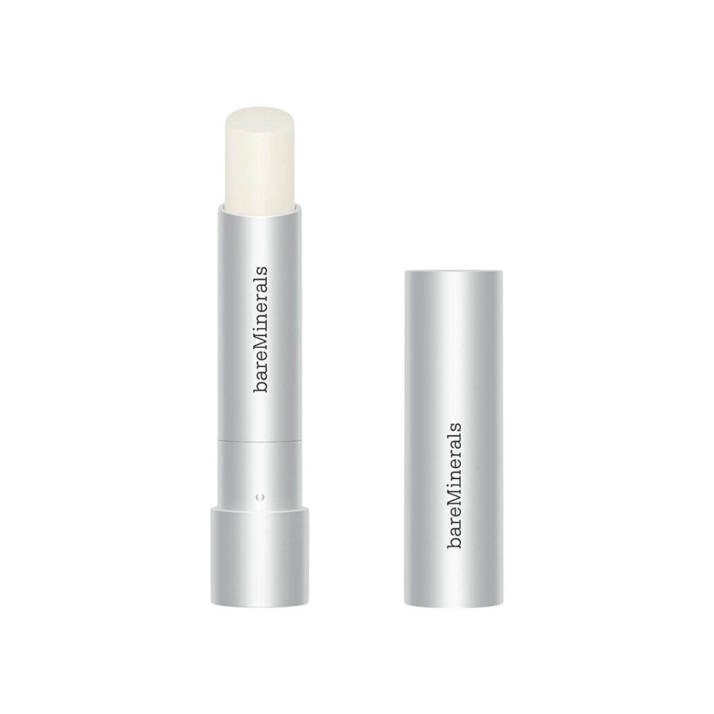 Silberfarbener Lippenpflegestift mit geöffneter Kappe. Marke: bareMinerals. Der Stift zeigt die Lippenpflege. Kappe daneben.