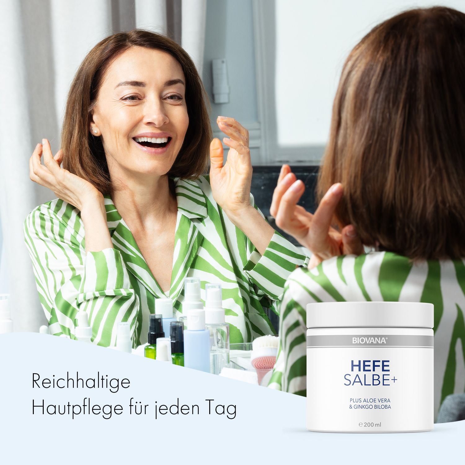Frau betrachtet sich im Spiegel. Auf dem Tisch steht ein Tiegel mit der Aufschrift: BIOVANA, HEFE SALBE+, e 200 ml.