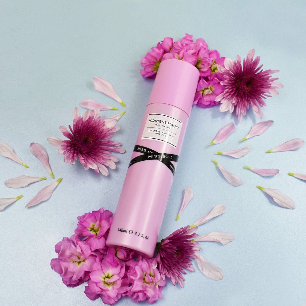 Rosa Körperspray, umgeben von rosa Blüten und Blütenblättern. Produktetikett mit Text: Midnight Magic, Miss So, 140ml.