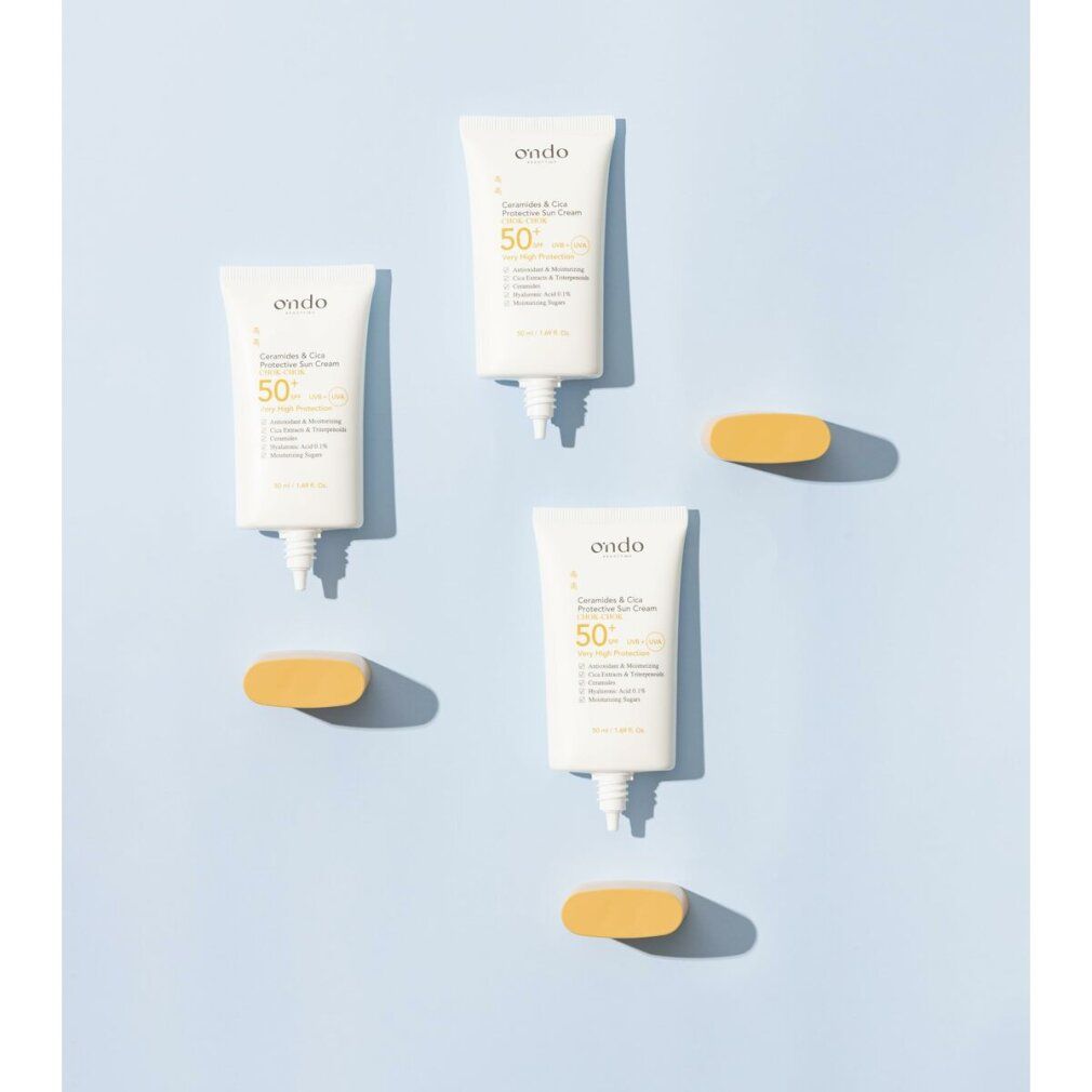 Drei Sonnencreme-Tuben und gelbe ovale Elemente auf blauem Hintergrund. Aufschrift: Ondo, Ceramide & Cica Protective Sun Cream, SPF 50+.