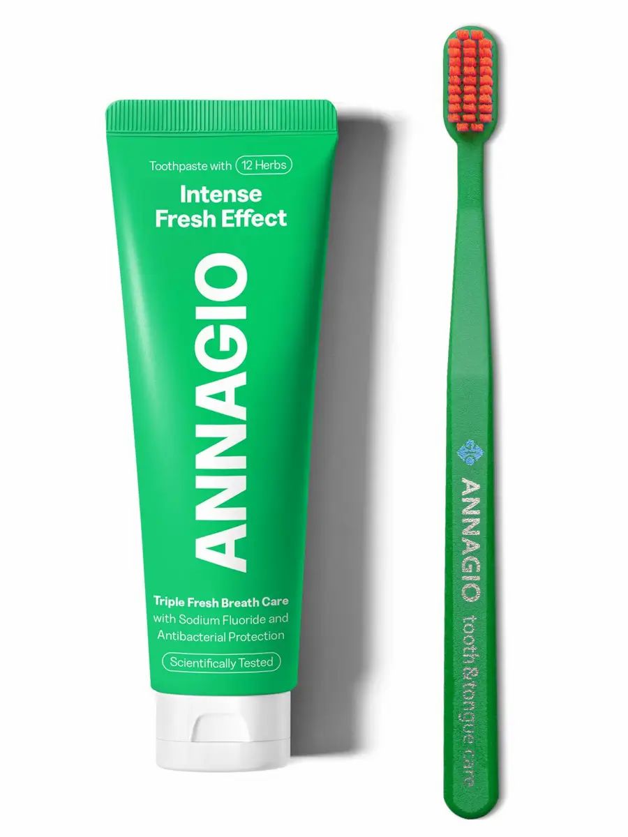 ANNAGIO Zahnpflege-Set: Grüne Tube Zahnpasta mit 12 Kräutern und eine grüne Zahnbürste mit orangefarbenen Borsten.