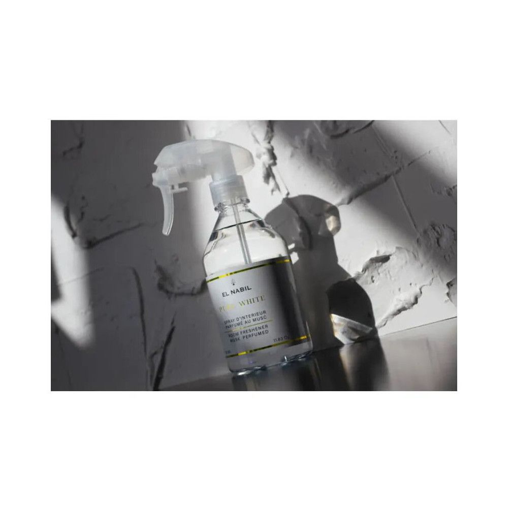 Transparente Sprühflasche mit weißem Etikett. Text: El Nabil, Pure White, Raumspray. Auf weißem Untergrund mit Schatten.