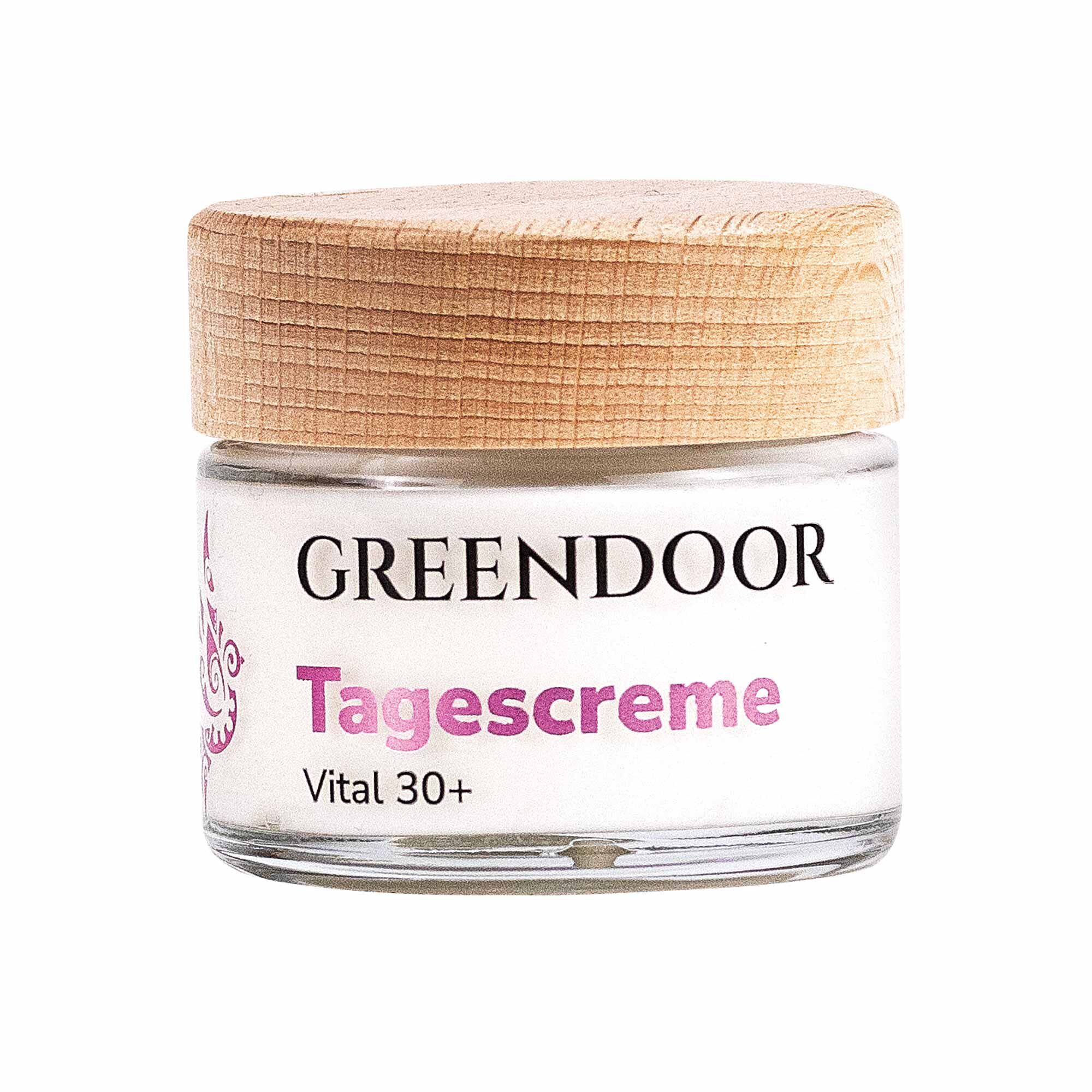 Creme-Glas mit Holzdeckel. Aufschrift: GREENDOOR Tagescreme Vital 30+. Weißes Glas mit rosa und schwarzer Schrift.
