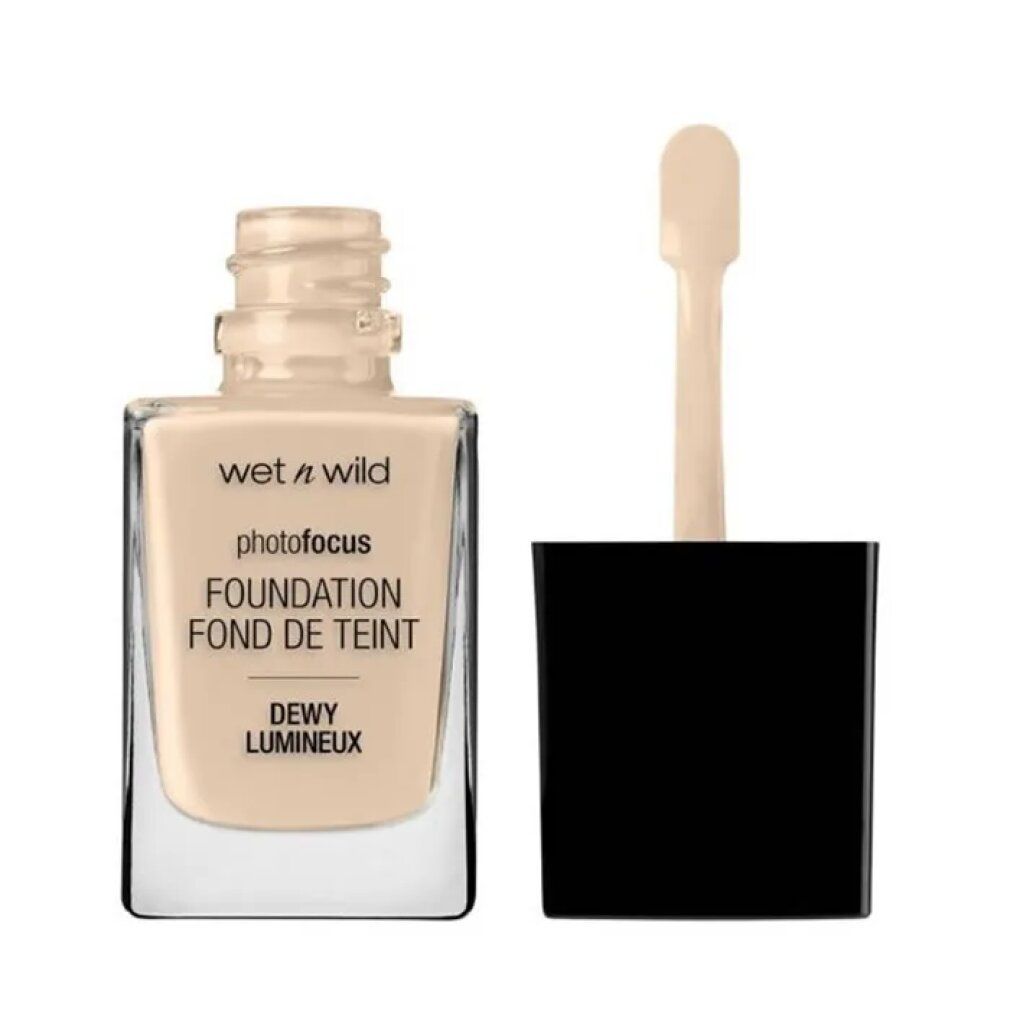 Wet n Wild Photo Focus Foundation. Glasflasche mit hellbeiger Flüssigkeit. Schwarzer Deckel mit Applikator. Produktname und Farbton.