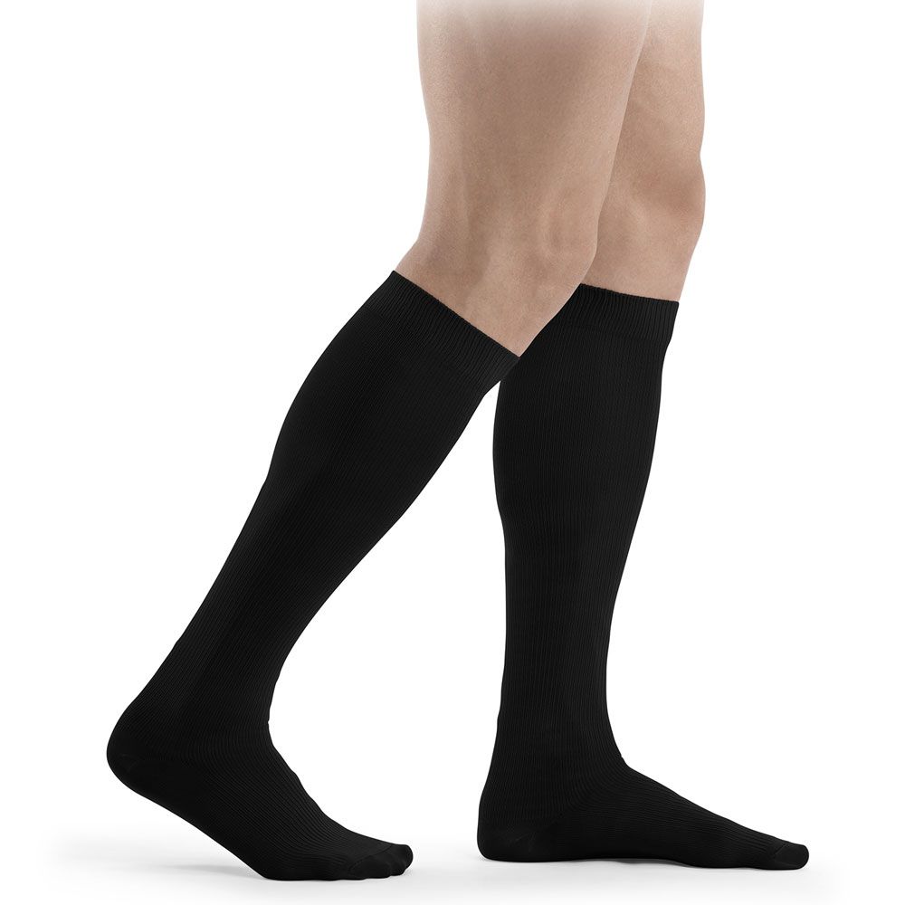 Schwarze Kniestrümpfe. Blick auf die Beine einer Person, die Strümpfe trägt. Der Stoff ist glatt und blickdicht.