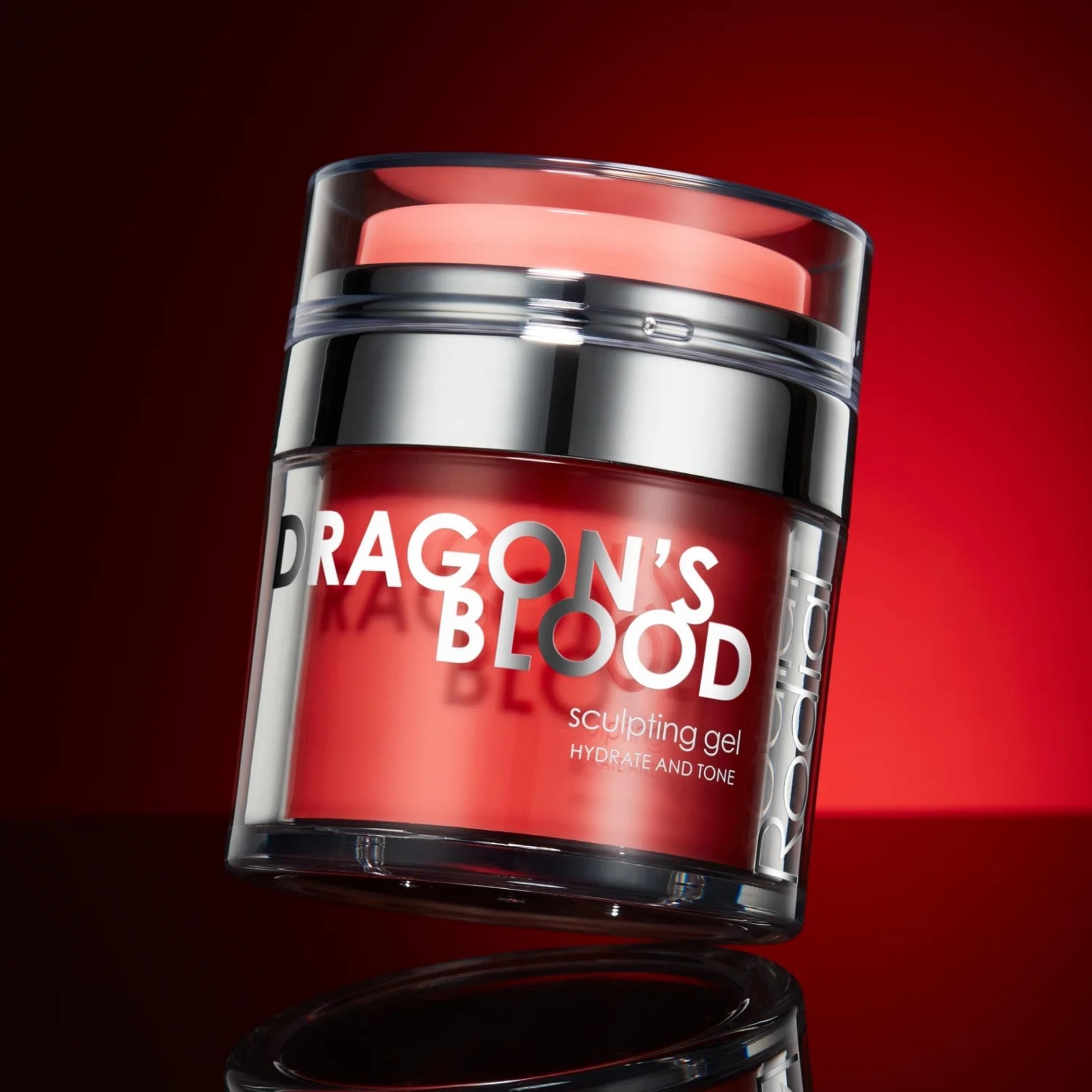 Roter Tiegel mit silbernem Deckel. Aufschrift: DRAGON'S BLOOD, Sculpting Gel. Transparenter Deckel. Roter Hintergrund.