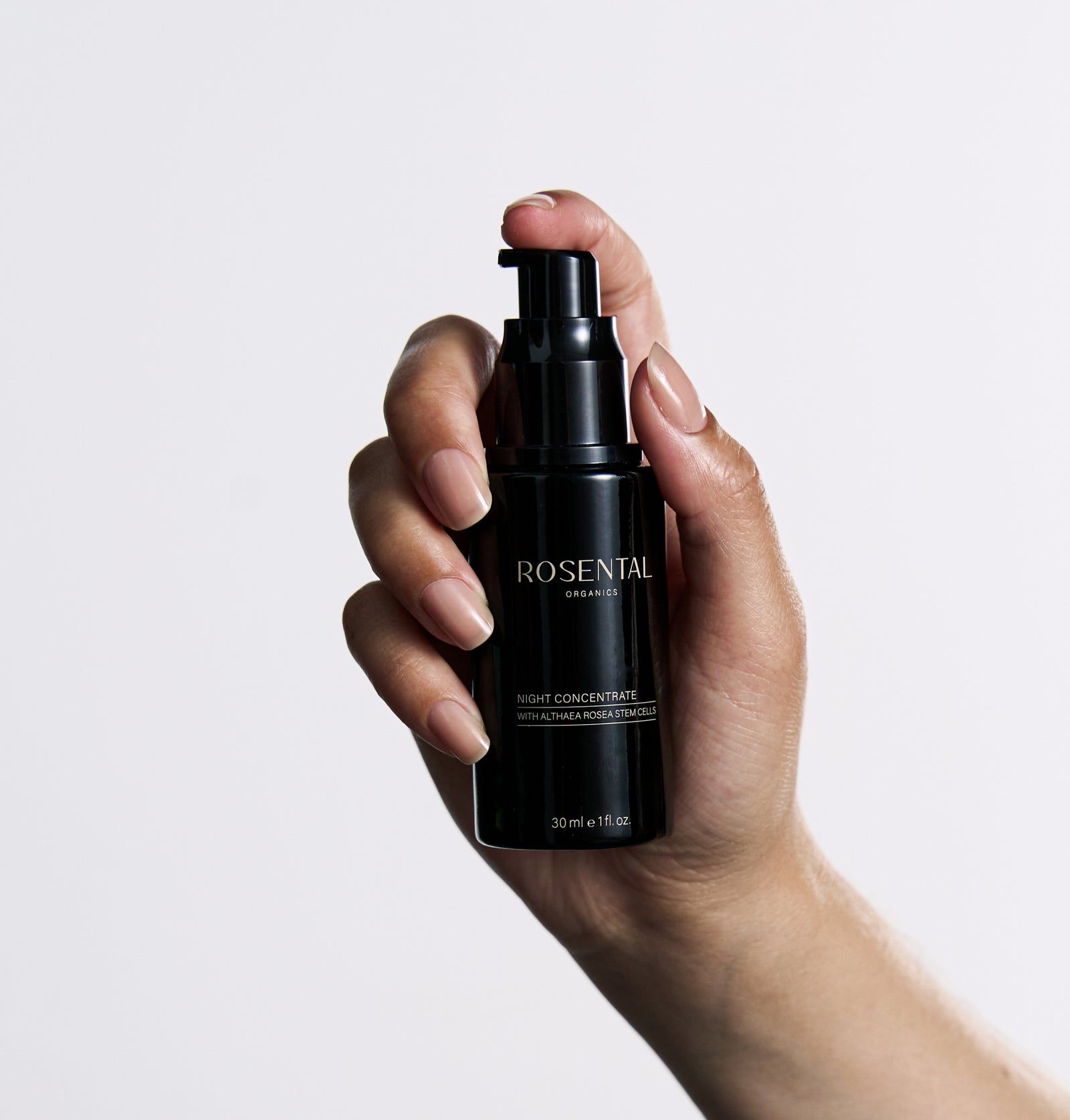Schwarze Flasche, in Hand gehalten. Schwarzer Pumpverschluss. Text: Rosental Organics, Night Concentrate.