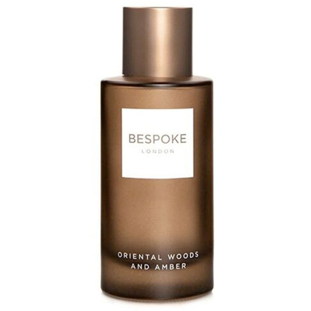 Parfümflakon mit goldfarbenem Deckel. Aufschrift: Bespoke London, Orientalische Hölzer und Amber. Braune Farbe.