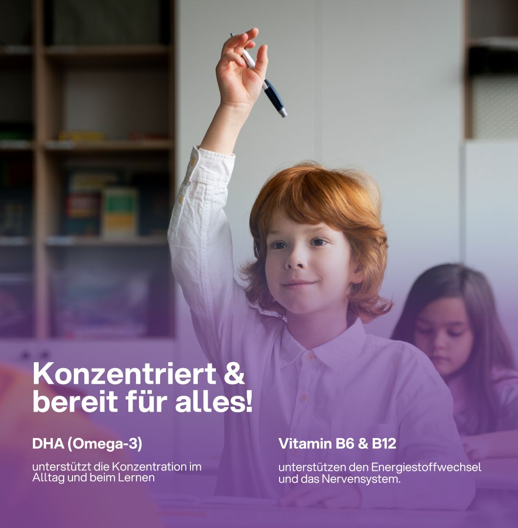 Ein Kind hebt die Hand in einem Klassenzimmer. Text: Konzentriert & bereit für alles! DHA (Omega-3), Vitamin B6 & B12.