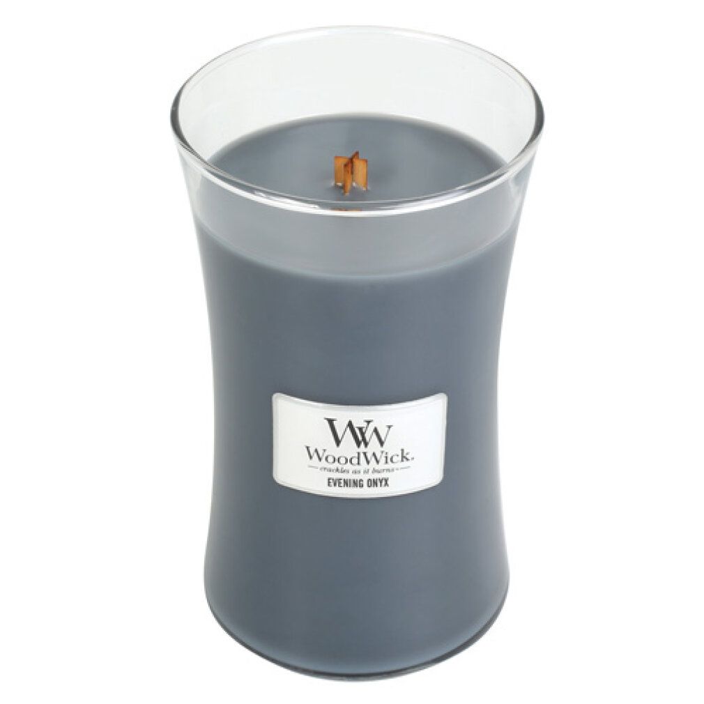 Graue Kerze im Glasbehälter. Holzdocht sichtbar. Etikett: WoodWick, Evening Onyx. Glasbehälter mit geschwungener Form.