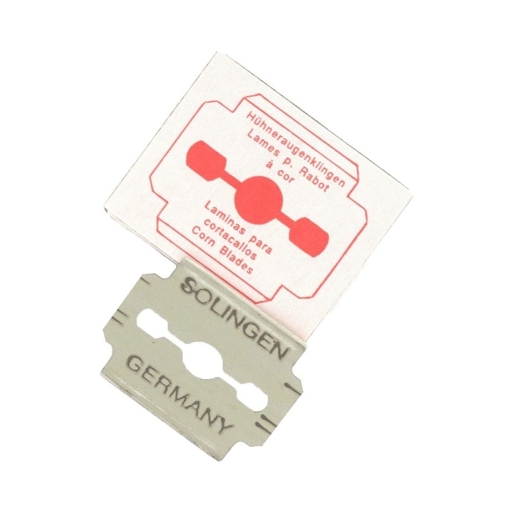 Metallklinge mit Verpackung. Aufschrift: Solingen, Germany. Verpackung mit roter Grafik und Text in mehreren Sprachen.