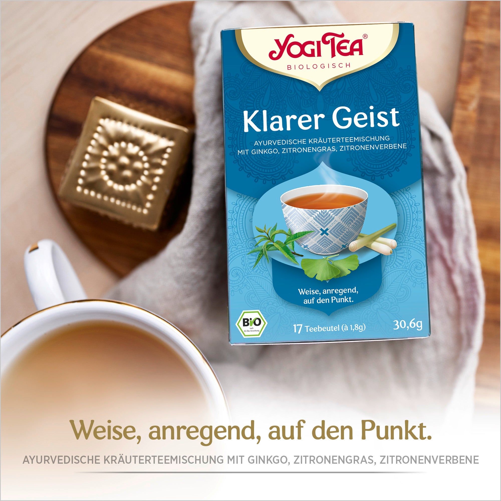 Blaue Teepackung "Klarer Geist" neben Tasse und Dekoration. Logo und Produktinformationen. Bio-Siegel.