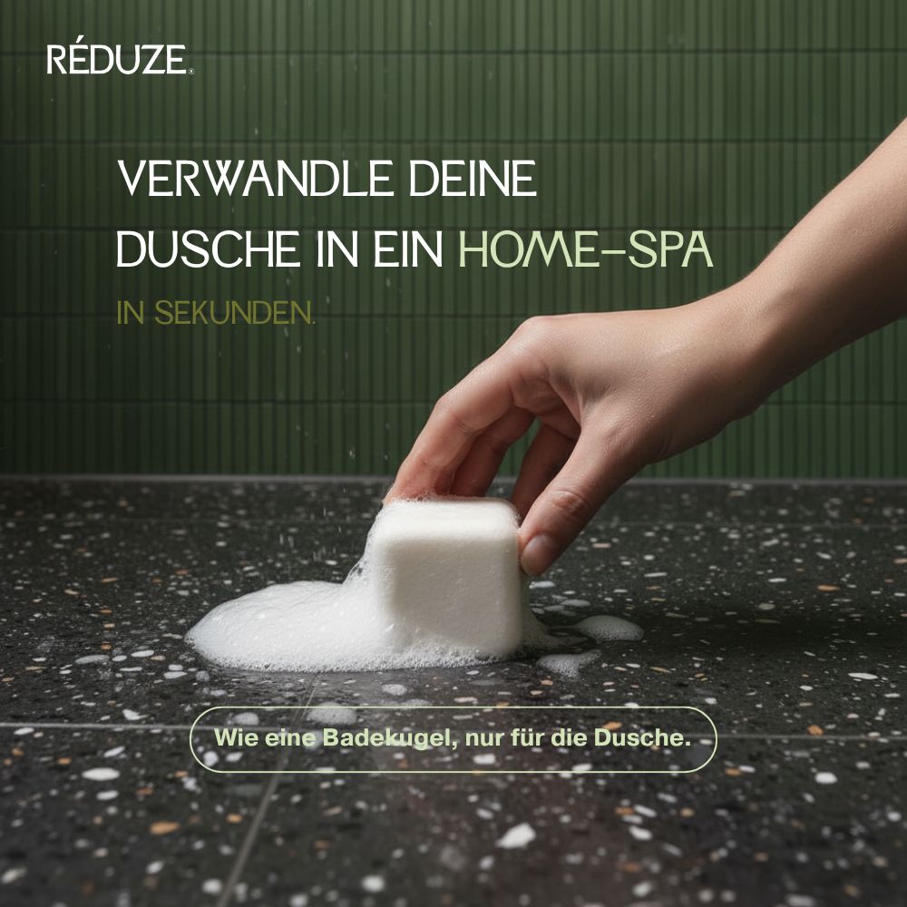 Hand legt weißen Duschwürfel auf eine Oberfläche mit Schaum. Text: RÉDUZE.