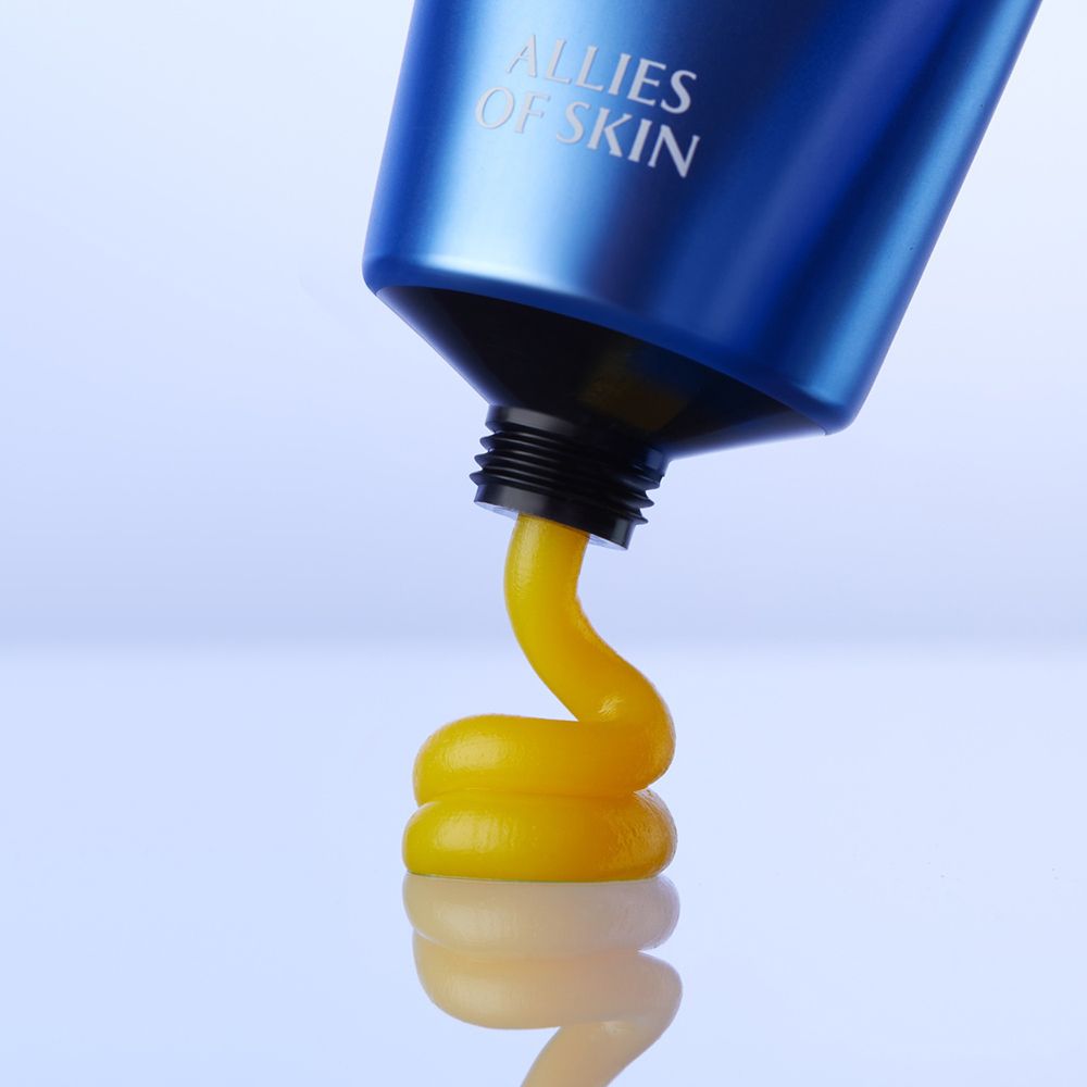 Blaue Tube, aus der gelbliche Substanz austritt. Marke: ALLIES OF SKIN.